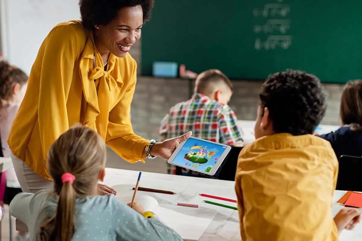 Image of teacher showing Skybrary to a child on a tablet