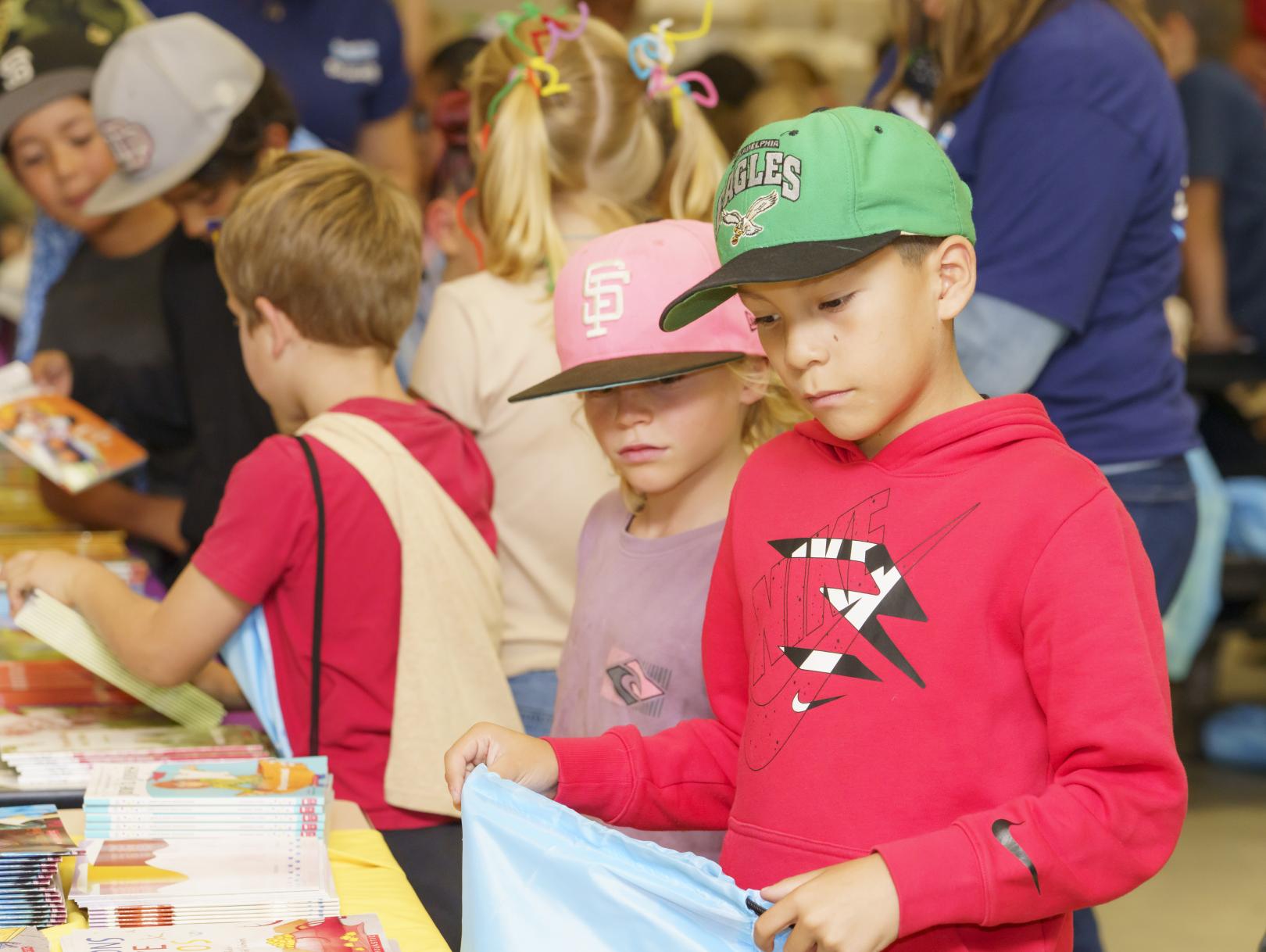 Boys picking books off a table