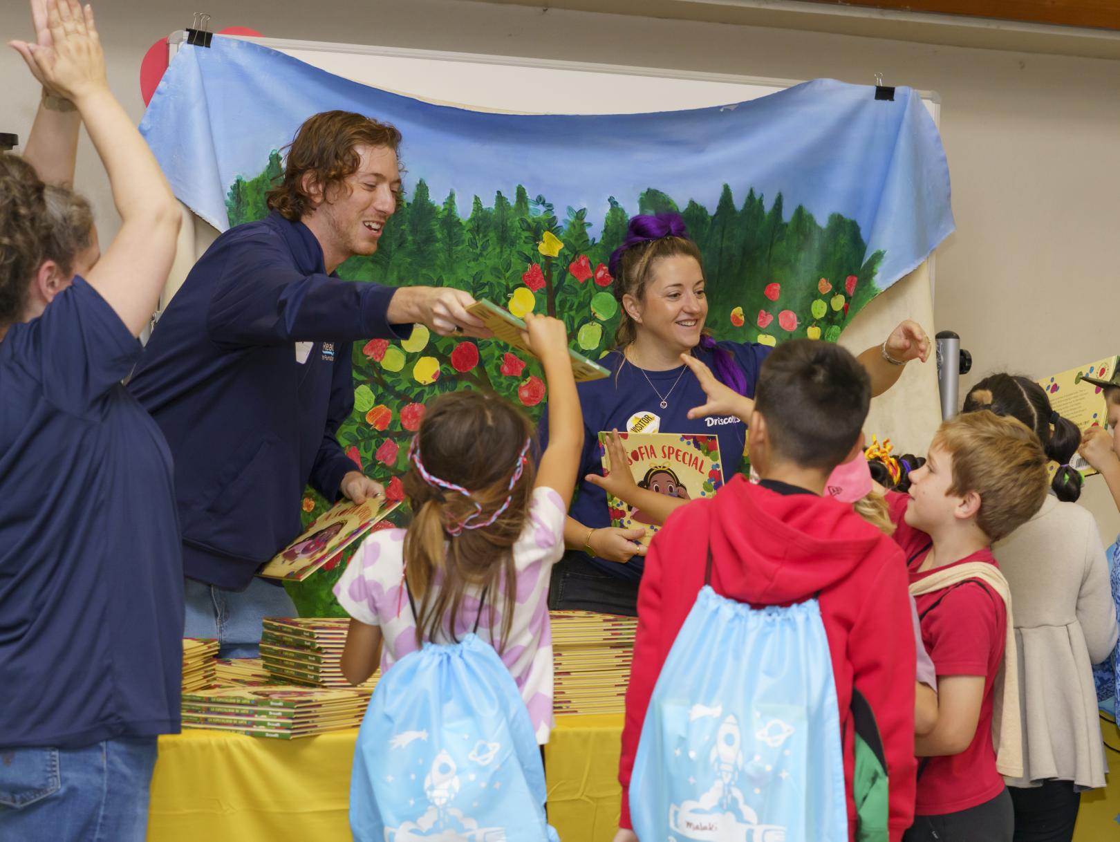 Volunteers handing out books to kids