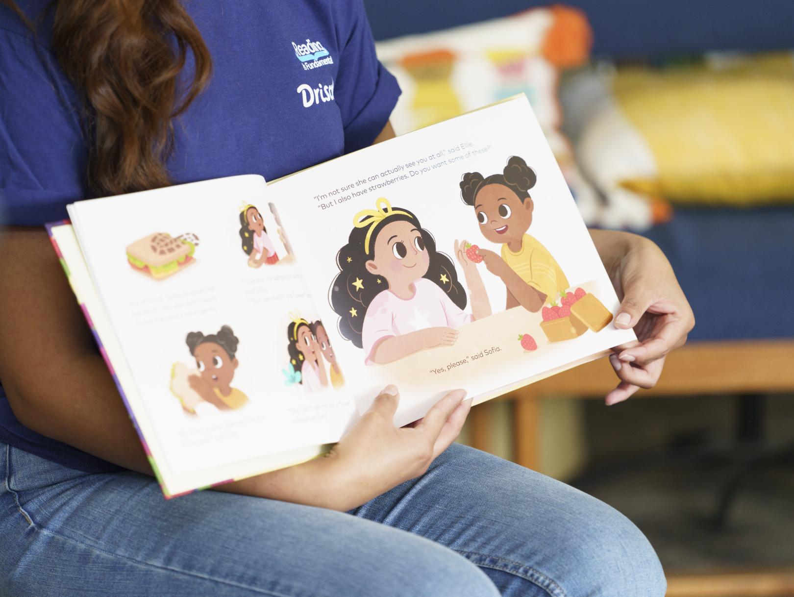 Volunteer holding book out